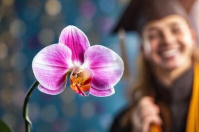 Graduado sonriente recibe premios en orquídeas